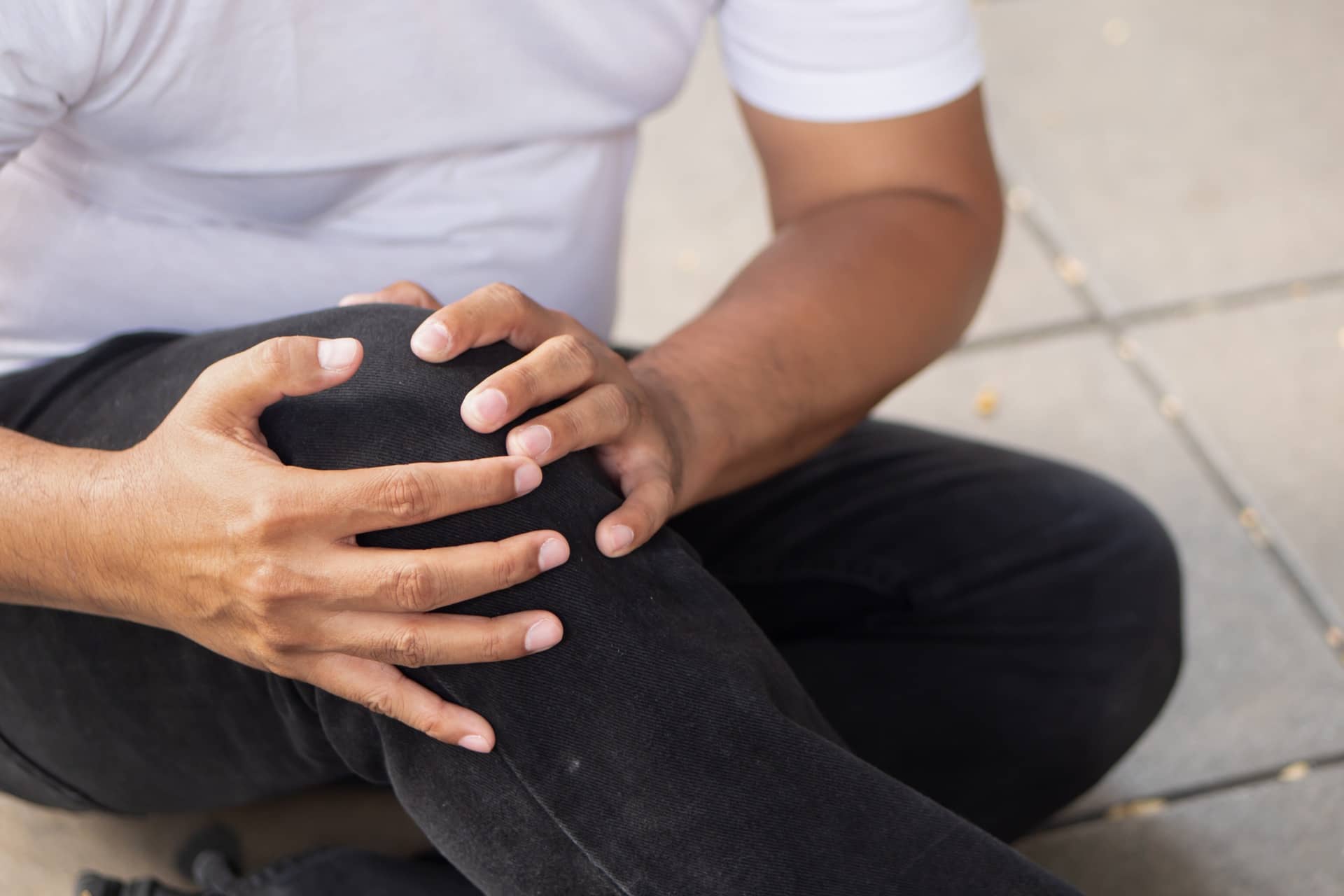 Persona con dolor de rodilla tras resbalón y caída